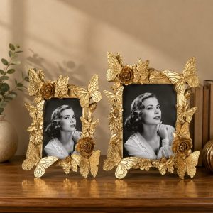 Gold butterfly photo frames with floral accents on a wooden tabletop
