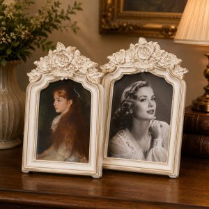 Elegant vintage white floral frames displaying classic portraits on a wooden table in a warm traditional interior